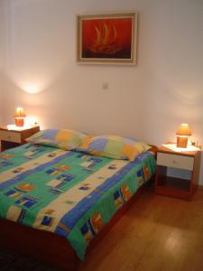 - une chambre avec un lit et 2 tables avec des lampes dans l'établissement Apartments & Rooms Lo & Mar, à Medulin
