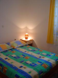 Bett in einem Schlafzimmer mit einer Lampe auf einem Tisch in der Unterkunft Apartments & Rooms Lo & Mar in Medulin