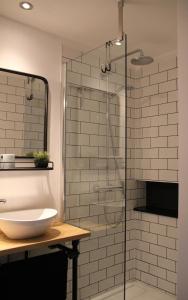 bagno con doccia in vetro e lavandino di Hoeve Altena Guesthouse a Woudrichem