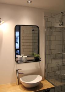 a bathroom with a sink and a mirror at Hoeve Altena Guesthouse in Woudrichem