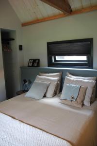 a bedroom with a large bed with pillows and a window at Hoeve Altena Guesthouse in Woudrichem