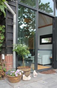 ein Haus mit einer Topfpflanze auf der Terrasse in der Unterkunft Hoeve Altena Guesthouse in Woudrichem