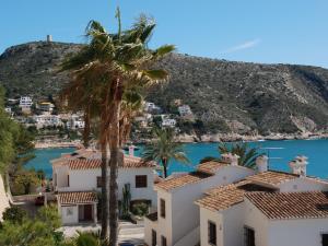 - une vue sur une villa avec un palmier dans l'établissement Nice villa in Moraira with private pool and lots of privacy, à Moraira