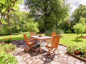 Saint-CybranetにあるFarmhouse in Saint Cybranet with Private Gardenの木製のテーブルと椅子が置かれた庭園