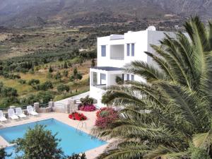 a villa with a swimming pool and a palm tree at Modish Villa in Lefkogia Crete with Swimming Pool in Lefkogeia