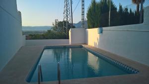 a swimming pool on the side of a house at Vista Bahia II Apartments- top floor with balcony views & ground floor with garden and BBQ in Albir