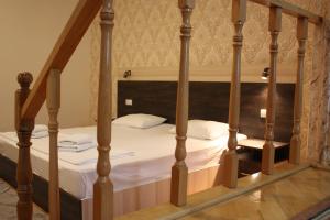 Una cama con sábanas blancas y almohadas en un dormitorio en Paradise Hotel, en Tiflis