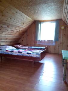 ein Schlafzimmer mit einem großen Bett in einem Holzzimmer in der Unterkunft Priedīši in Aglona + 22 Fotos