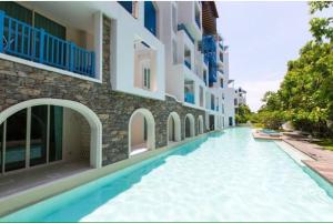 a swimming pool in front of a building at Chelona Hua Hin E505 in Khao Tao