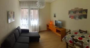 ein Wohnzimmer mit einem Sofa und einem TV in der Unterkunft Betiko in Vitoria-Gasteiz