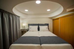 フンシャルにあるApartments Madeira City Centerのベッドルーム1室(大型ベッド1台、枕2つ付)
