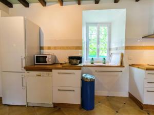 a kitchen with a refrigerator and a microwave at Spacious house with private pool in Petit-Palais-et-Cornemps