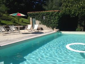 una piscina con mesa, sillas y sombrilla en Castelo Do Castro, en Carrazedo