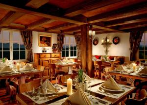 Bürgenstock Hotels & Resort - Taverne 1879 في بورغنستوك: غرفة طعام مع طاولات وكراسي ونوافذ