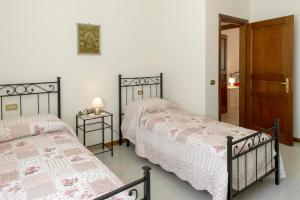 a bedroom with two beds and a door at La Casa dei Pini in Gubbio