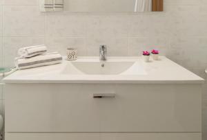 a white bathroom sink with towels and flowers on it at La Casa dei Pini in Gubbio +26 photos