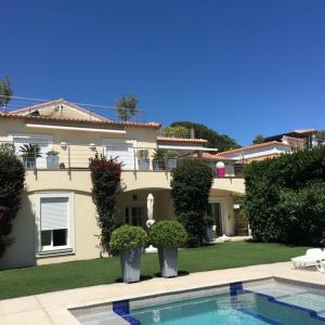 uma casa grande com uma piscina em frente em Sainte Maxime Studio 2 em Sainte-Maxime