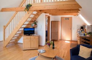 a living room with a wooden staircase and a table at Ferienweingut Pies Ellenz-Poltersdorf in Ellenz-Poltersdorf
