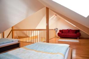 a bedroom with a bed and a red couch at Ferienweingut Pies Ellenz-Poltersdorf in Ellenz-Poltersdorf