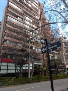 un letrero de la calle frente a un edificio alto en Encomenderos Apart Hotel, en Santiago