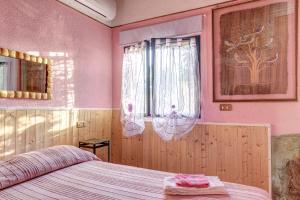 a bedroom with a bed with pink walls and a window at Secret Haven in La Croce +16 photos