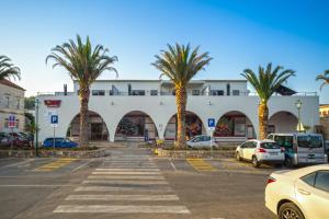 a parking lot with palm trees in front of a building at Madrugada Old City in Stari Grad