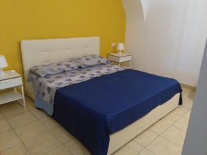 a bedroom with a bed with a blue comforter at Affaccio al barocco in Catania