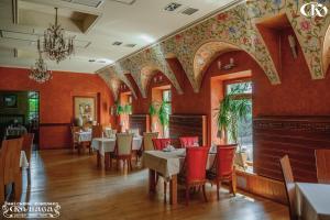 a restaurant with red walls and tables and chairs at Hotel Complex Kupava in Podvorki