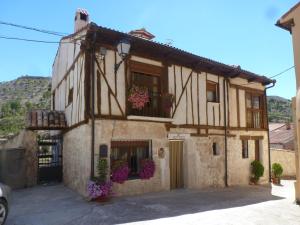 a building with flower boxes on the windows at Casa Rural Marina in Curiel de Duero