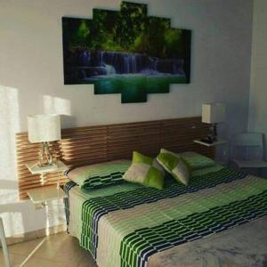 een slaapkamer met een bed en een schilderij aan de muur bij suite the natural color in Selargius