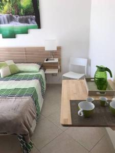 塞拉爾朱斯的住宿－suite the natural color，一间卧室配有床和桌子,上面有杯子