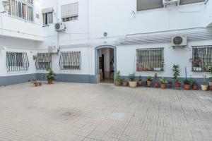 a white building with potted plants in front of it at Apartamento cerca de la Playa y el Centro in Valencia