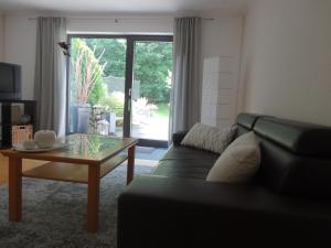 a living room with a black couch and a glass table at Stadt und Wald in Trier