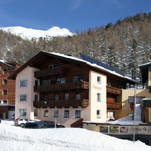 ein Hotel im Schnee mit einem Berg im Hintergrund in der Unterkunft Pension Timmelseck in Obergurgl