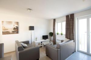 a living room with two chairs and a couch and a television at Evancy Platier d'Oye - Oye-Plage in Oye-Plage