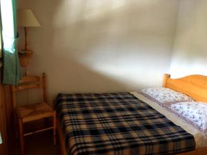 - une petite chambre avec un lit et une chaise dans l'établissement Les Jardins Alpins - Apartment, à Saint-Gervais-les-Bains