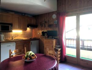 - une cuisine avec une table et un bol de fruits dans l'établissement Les Jardins Alpins - Apartment, à Saint-Gervais-les-Bains
