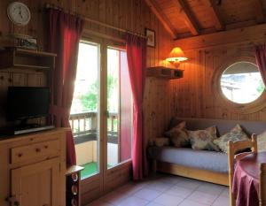 - un salon avec un canapé et une fenêtre dans l'établissement Les Jardins Alpins - Apartment, à Saint-Gervais-les-Bains