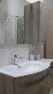 a bathroom with a white sink and a mirror at La casa di Laura in Tortolì