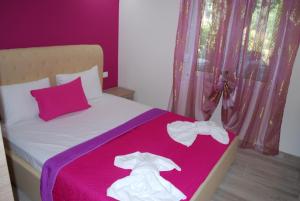 リメナリアにあるFamily house Emeraldのベッド(ピンクの毛布と白い靴付)