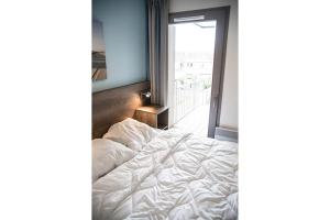 a bedroom with a white bed and a window at Evancy Villa les Peupliers in Bray-Dunes