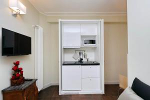 una cucina bianca con lavello e microonde di Piazza Venezia Grand Suite a Roma