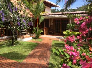 a garden area with a patio and a house at Hotel Cabinas Tropical in Puerto Viejo