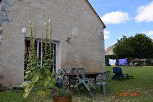 une table et des chaises devant un bâtiment dans l'établissement Au calme, à Houssay