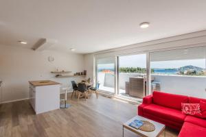 sala de estar con sofá rojo y ventana grande en Apartments Sunrise, en Preko