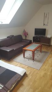 uma sala de estar com um sofá e uma mesa de centro em Apartments zum Bayrisch Pub em Weissenhorn