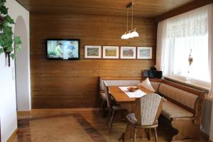 ein Esszimmer mit einem Tisch und einem TV an der Wand in der Unterkunft Ferienwohnung Haus am Dürrberg "St. Barbara" in Warmensteinach