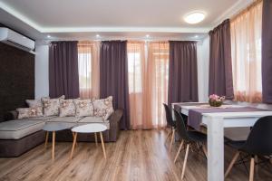 - un salon avec un canapé et une table avec des chaises dans l'établissement Apartment Nikol, à Sozopol