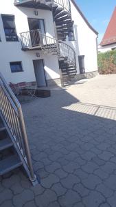 ein Gebäude mit einer Treppe und einer Terrasse mit Stühlen in der Unterkunft Apartments zum Bayrisch Pub in Weißenhorn