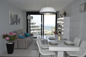 アレナレス・デル・ソルにあるAmazing Infinity View Apartmentの白いリビングルーム(テーブル、ソファ付)